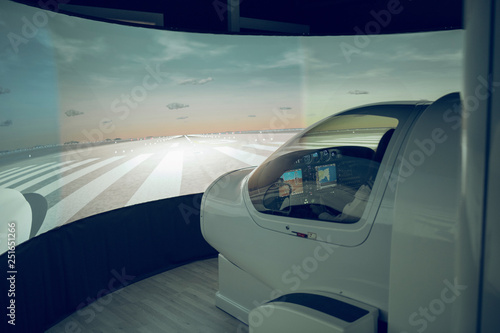 Side view of male trainee flying flight simulator seen through windshield photo