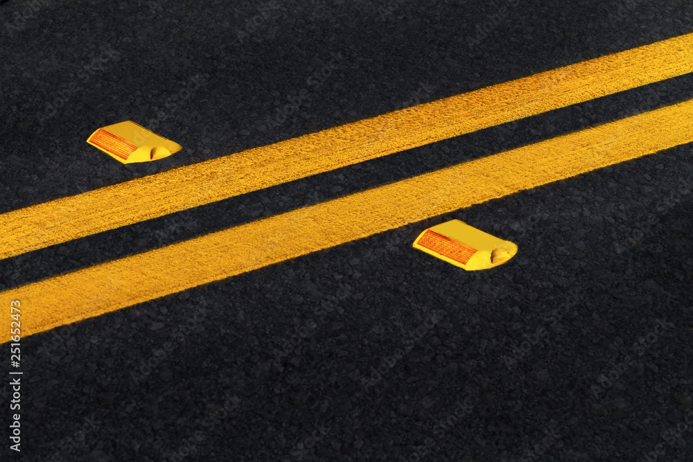 Double yellow lines on black asphalt road with reflectors Photos