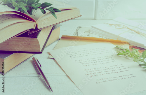 Books, pen, poems of Shakespeare on the old wooden table. The process of writing a love letter