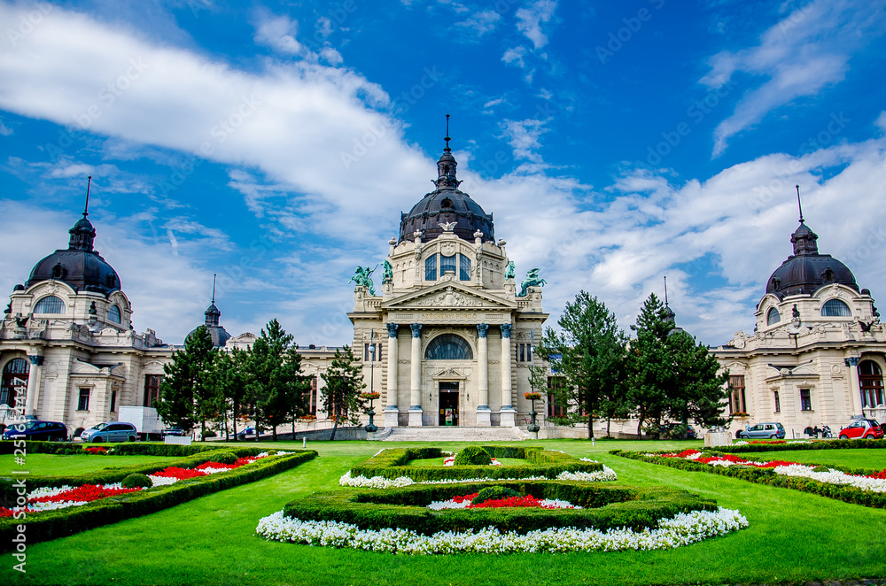A cloudy day in front of Széchenyi Medicinal Bath in Budapest with a very well cared and colorful lawn 