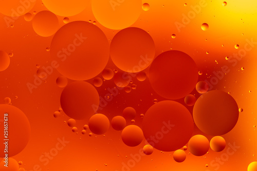 oily drops in water with colorful background, close-up 