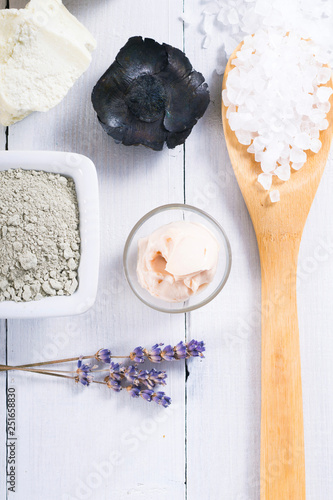 spa massage mud and clay powder, soaps, bath salt, shea butter and lavenders on white wood table background