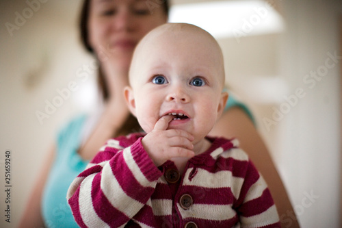 Portrait of a young baby with a finger in his mouth. photo