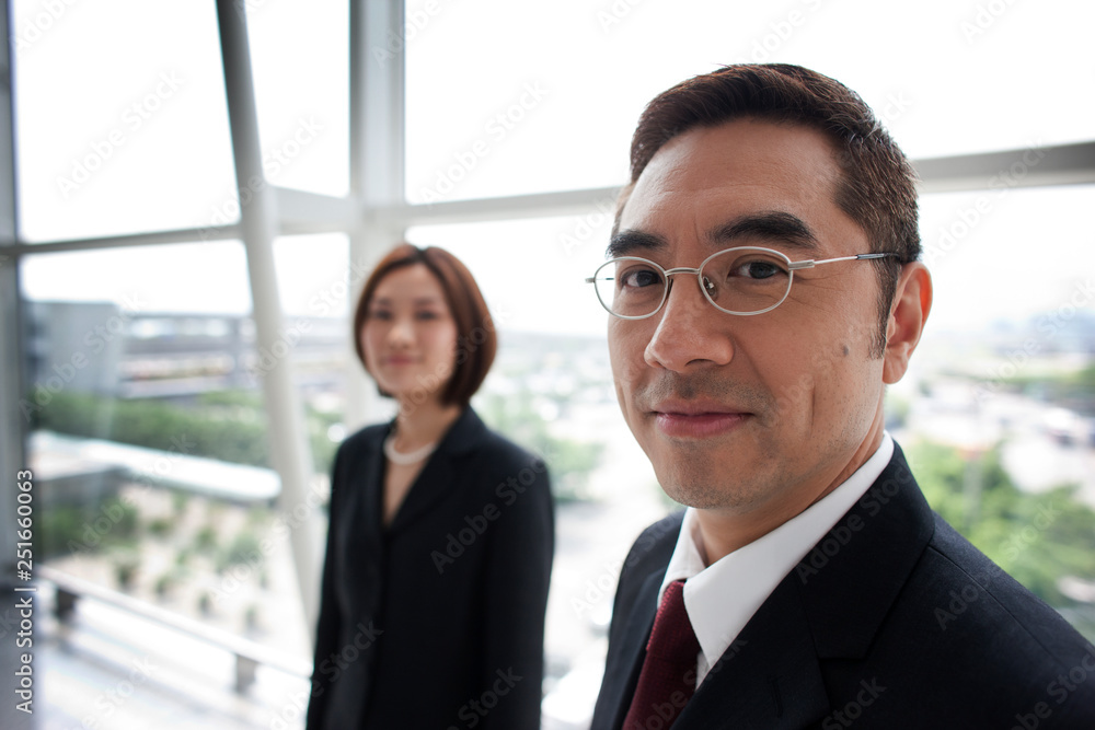 Portrait of Chinese businessman with his colleague in the background. Portrait of Chinese businessman with his colleague in the background.