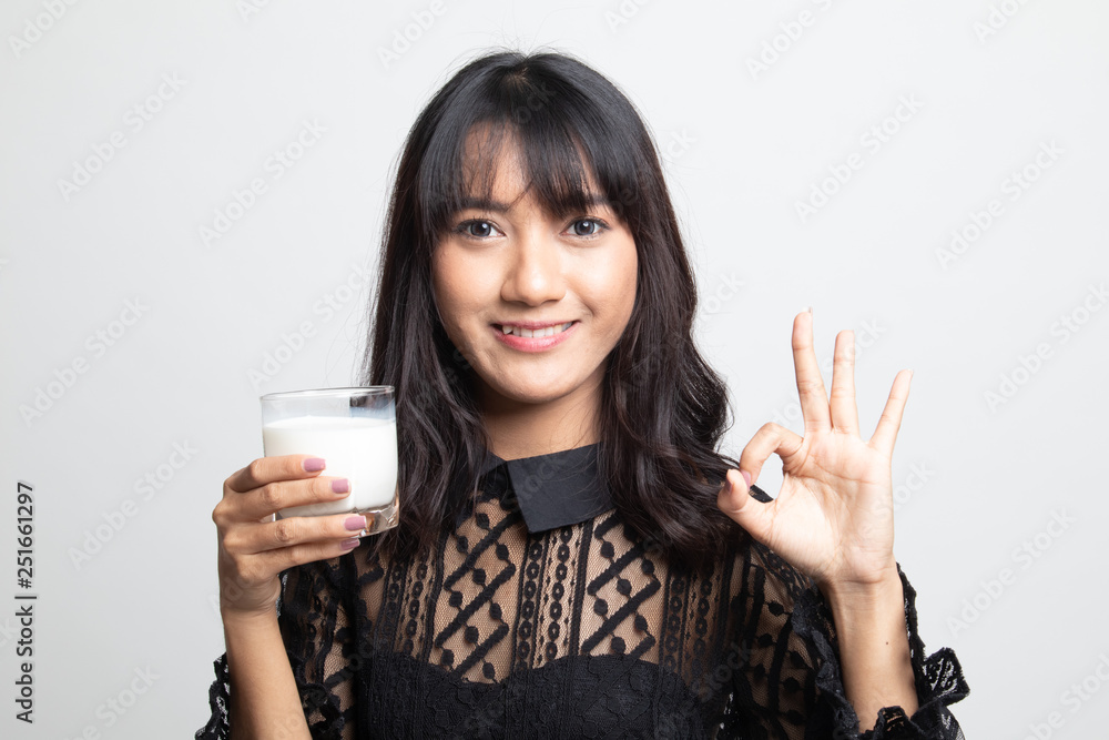 Healthy Asian woman drinking a glass of milk show OK sign. Healthy Asian woman drinking a glass of milk show OK sign.