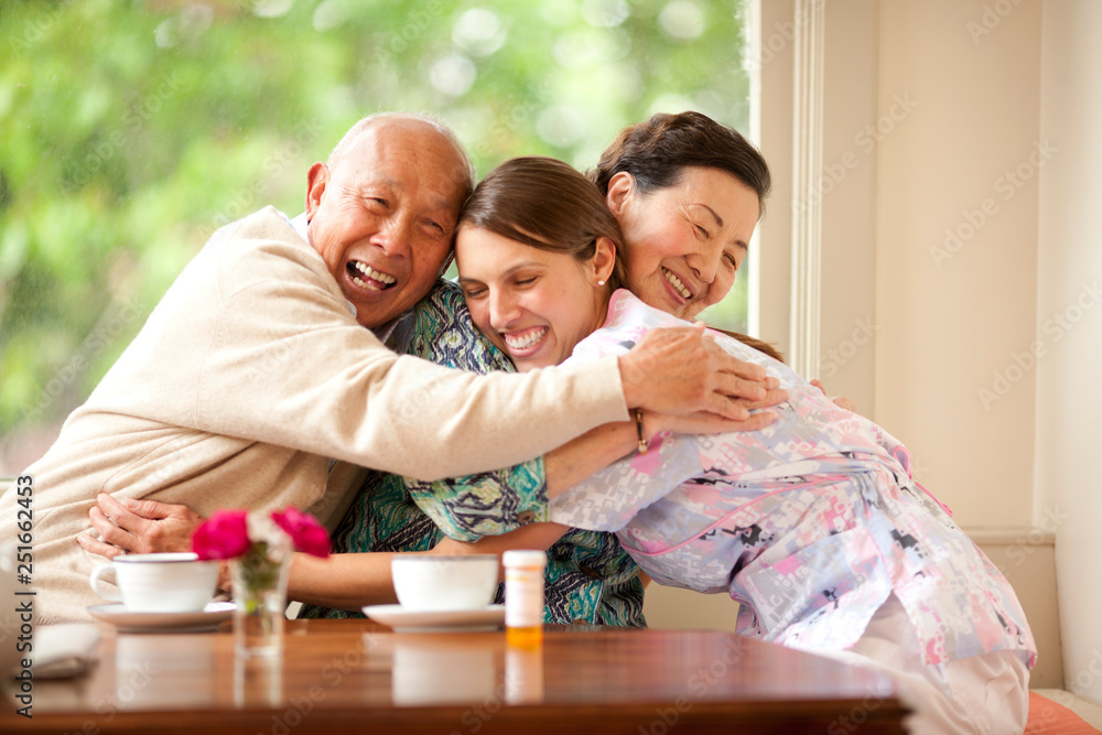Senior couple hugging their nurse. Senior couple hugging their nurse.