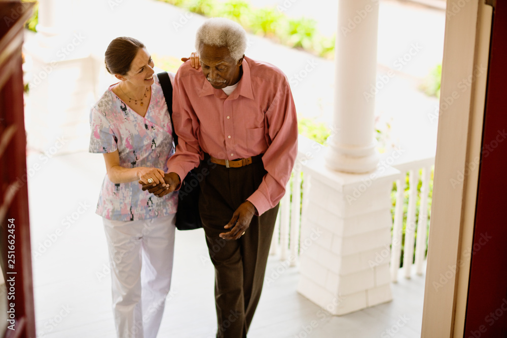 Young nurse helps her elderly patient to walk. Young nurse helps her elderly patient to walk.