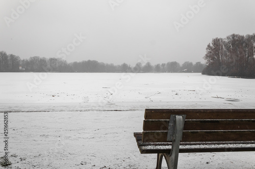 park bench overlooking the snow covered ice lake winter scene