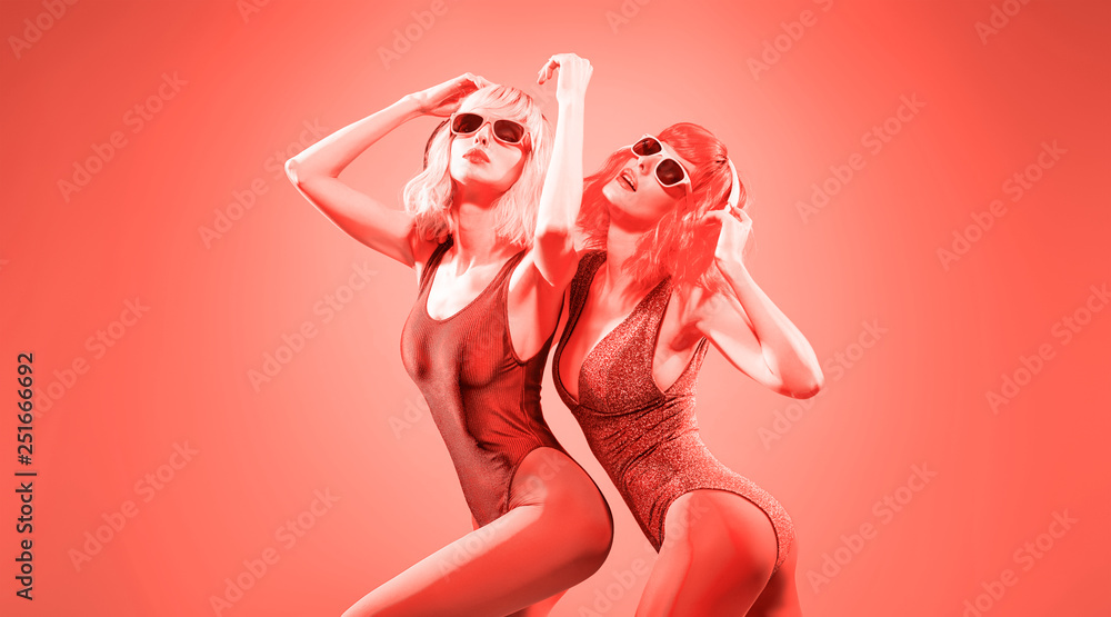 Fashion contemporary coral neon style. Two young graceful woman in party DJ bodysuit dance. Disco 80s 90s summer vibes. Adorable fashionable sexy girl, trendy neon makeup. Creative art coral color