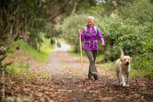 Mature woman on a rural hike with her dog.