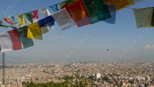 Waving prayer flags against cityscape. View of waving multicolored prayer flags on strings above cityscape of Kathmandu valley, Swayambhunath Stupa (Monkey Temple), Nepal
