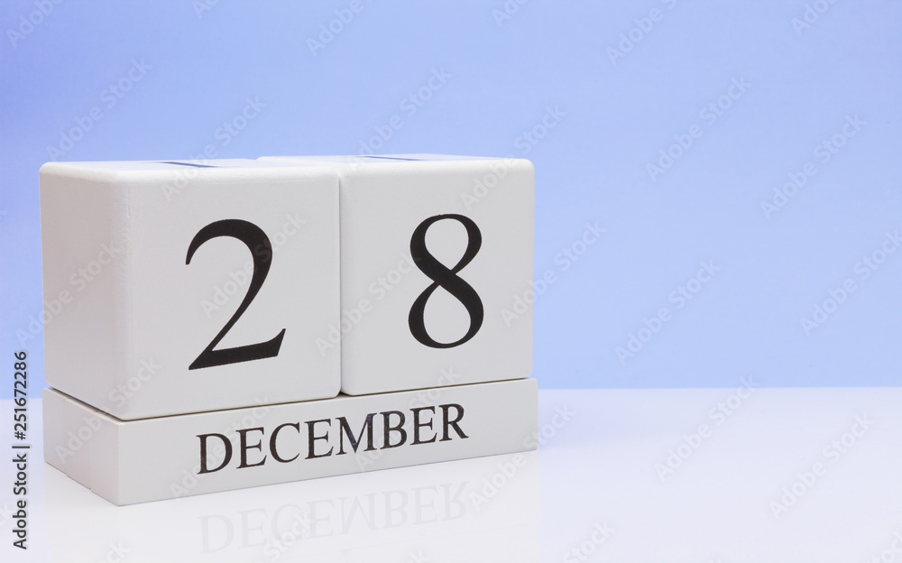 December 28st. Day 28 of month, daily calendar on white table with reflection, with light blue background. Winter time, empty space for text December 28st. Day 28 of month, daily calendar on white table with reflection, with light blue background. Winter time, empty space for text