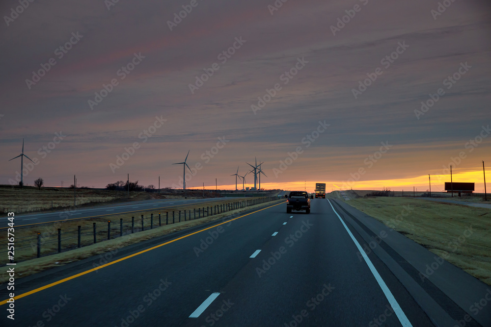 Road Leading to view of the Texas wind turbine farms in the colorful sunset showing