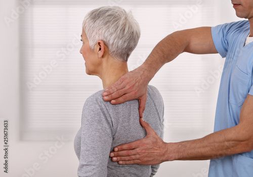 Mature Woman having chiropractic back adjustment. Osteopathy  Physiotherapy  Sport injury rehabilitation concept  holistic care
