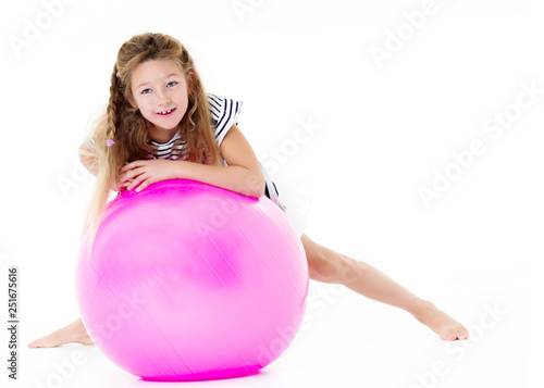 Little girl is playing with a ball