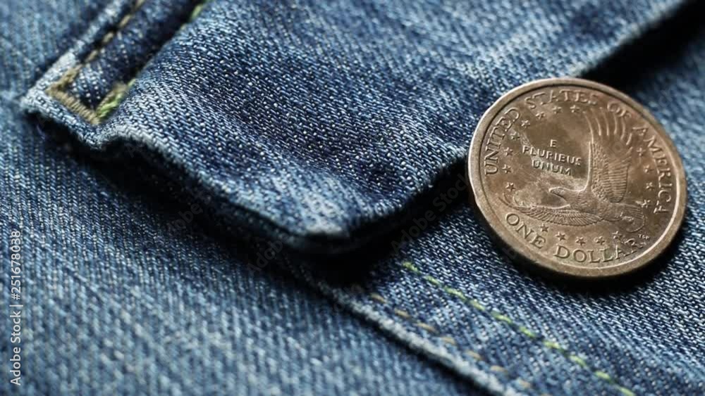 Dollar coin on a denim fabric trouser Dollar coin on a denim fabric trouser