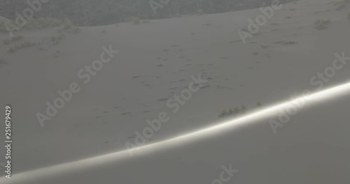 Big dune with wind blowing sand over surface at sunset, detail of dune's top. Huancar dunes, Abra Pampa, Jujuy, Argentina