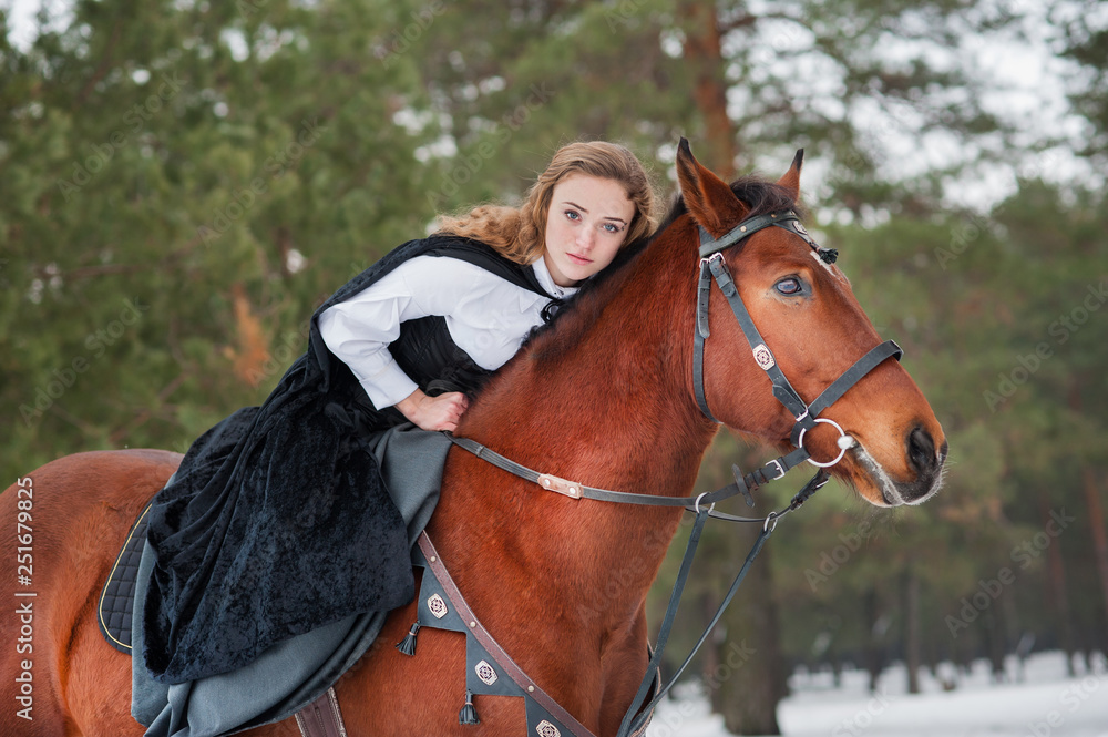 Fototapeta premium Beautiful girl in historical clothes riding a horse