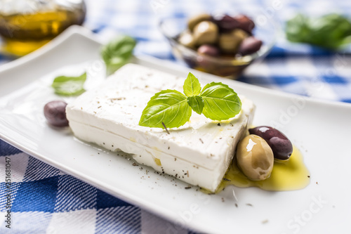 Greek cheese feta with olive oil olives and basil leaves photo