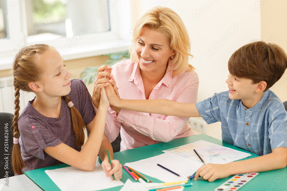 Two little pupil and teacher giving high five to each other. Two little pupil and teacher giving high five to each other.