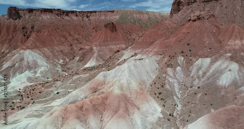 Aerial drone scene of colorful mountainous landscape. Flying backwards above dry valley with red, orange and white colors. Discovering 4x4 expedition. Mars valley, Valle de Marte, Cusi Cusi