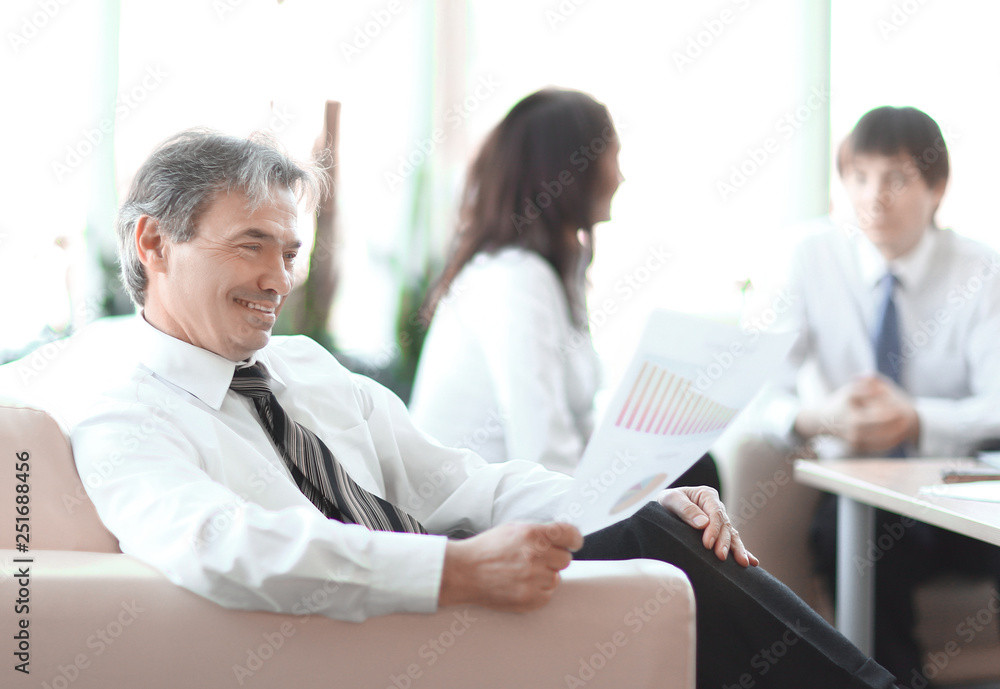 Obraz premium businessman pondering a document sitting in a modern office