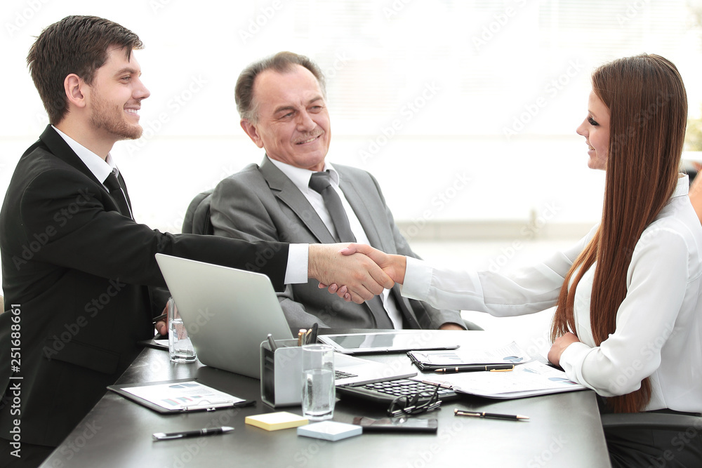 business woman shaking hands with an adult business partner. business woman shaking hands with an adult business partner.