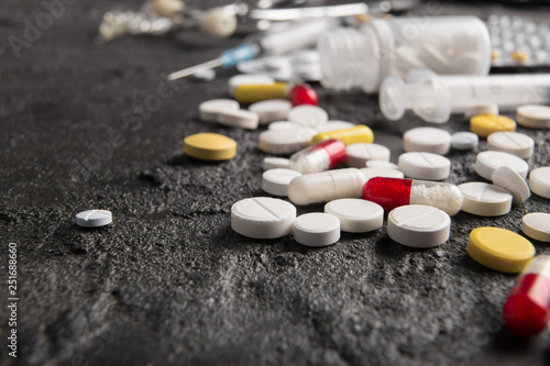 Assorted pharmaceutical medicine pills, tablets and capsules. Black background. photo