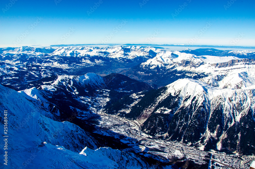 Panoramic view of mountains and french town called Chamonix-Mont-Blanc. All around the summits of Alps covered with snow.  Ideal destination for winter holiday full of skiing and snowboarding.