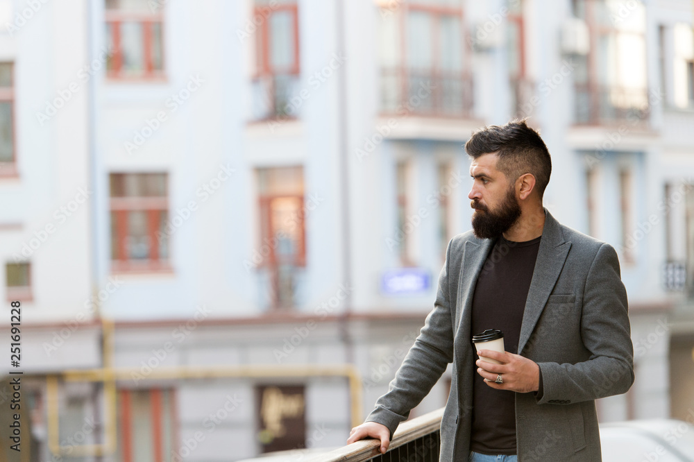 Beginning of busy day. Hipster with paper cup walking in city. Businessman in hipster style holding takeaway coffee. Bearded man enjoying morning coffee. Drinking his cup first thing in the morning Beginning of busy day. Hipster with paper cup walking in city. Businessman in hipster style holding takeaway coffee. Bearded man enjoying morning coffee. Drinking his cup first thing in the morning