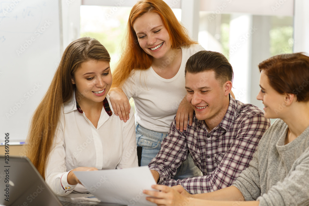 Ambitious young students learning new material on interesting courses. Qualified female teacher helping and explaining topic while happy pupils listening carefully. Concept of modern studying. Ambitious young students learning new material on interesting courses. Qualified female teacher helping and explaining topic while happy pupils listening carefully. Concept of modern studying.