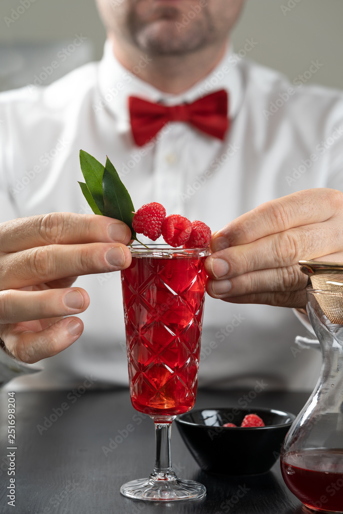 classy fancy bartender mixologist makes prepares alcohol drink cocktail bowtie raspberry