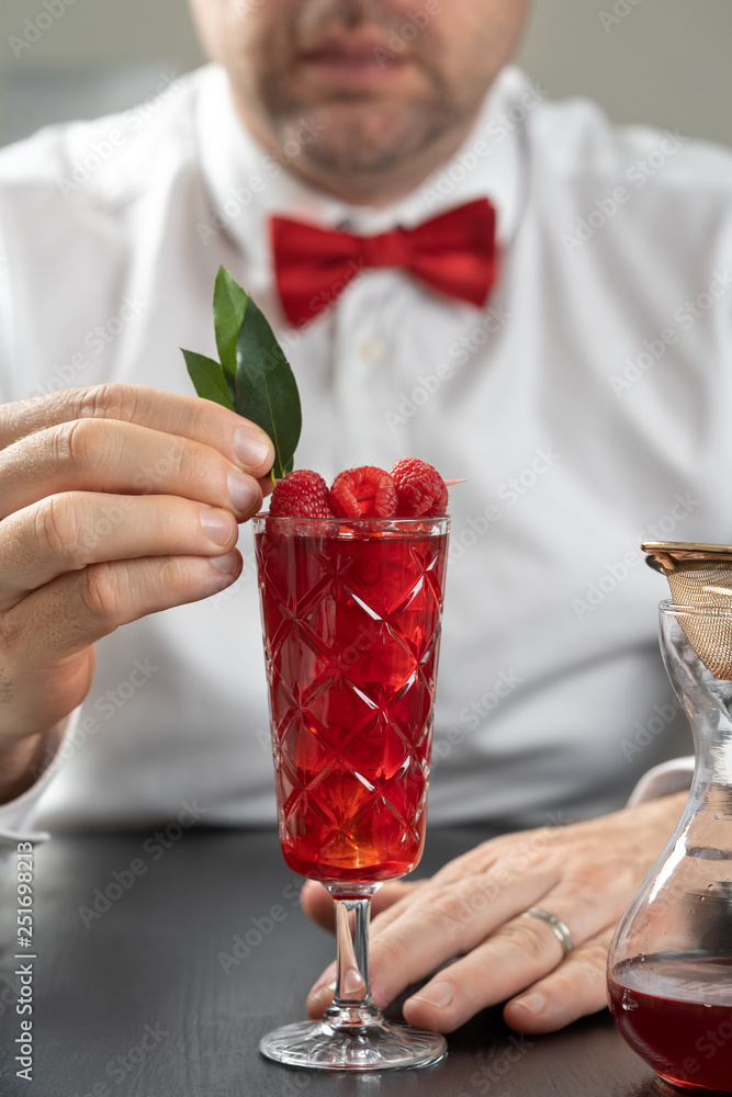 classy fancy bartender mixologist makes prepares alcohol drink cocktail bowtie raspberry
