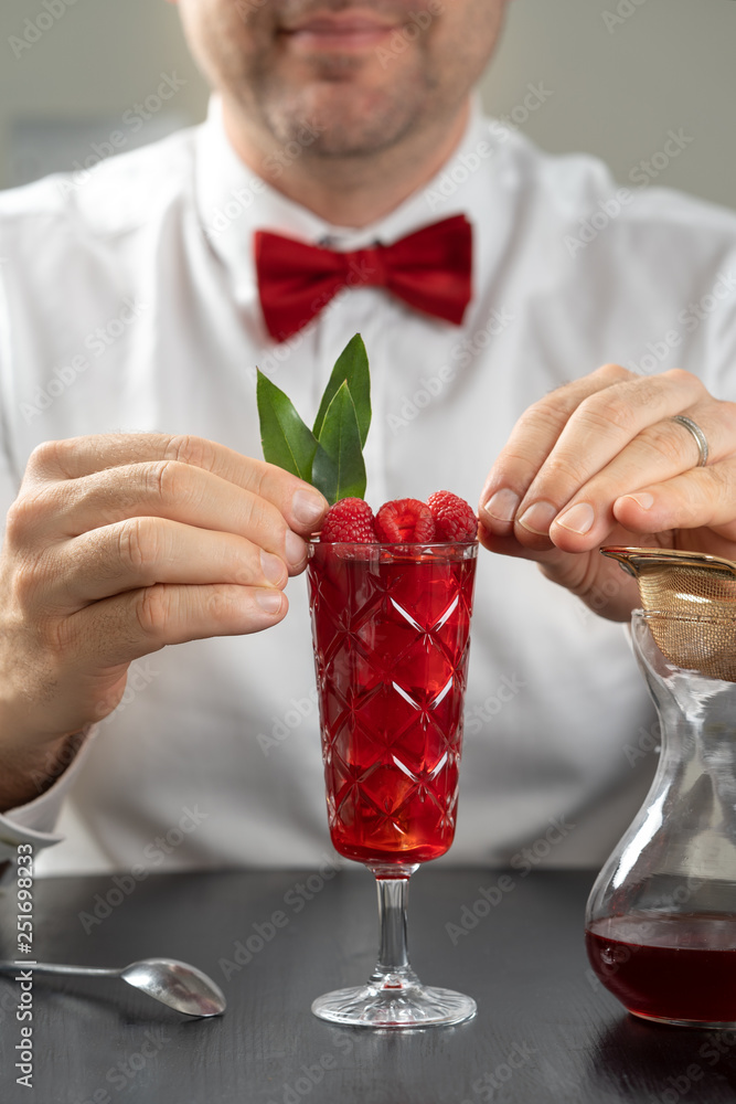 classy fancy bartender mixologist makes prepares alcohol drink cocktail bowtie raspberry