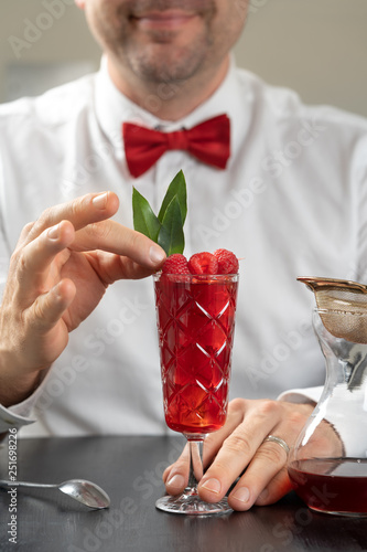 Obraz na płótnie classy fancy bartender mixologist makes prepares alcohol drink cocktail bowtie raspberry w salonie