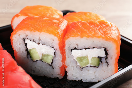 Box with tasty sushi rolls, closeup. Food delivery service