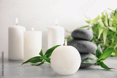 Beautiful spa composition with candles and stones on table