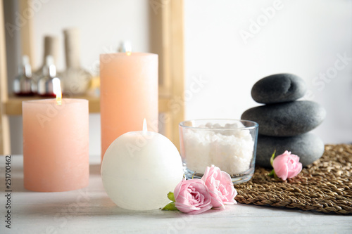 Beautiful spa composition with candles and stones on wooden table