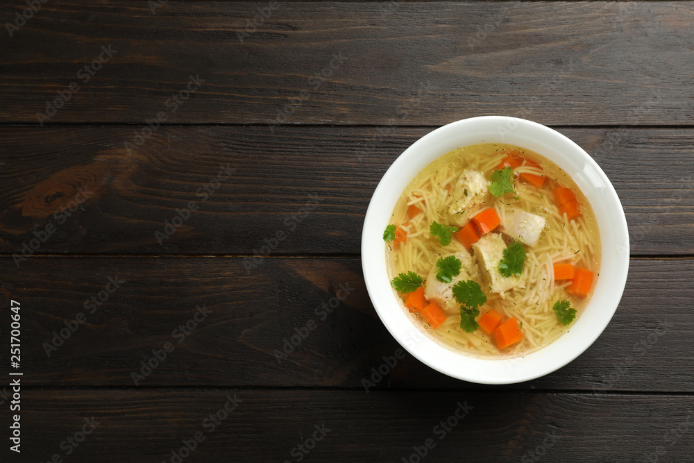 Homemade chicken soup served on wooden background, top view with space for text Homemade chicken soup served on wooden background, top view with space for text