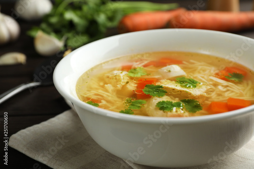 Plate with fresh homemade chicken soup on table, closeup