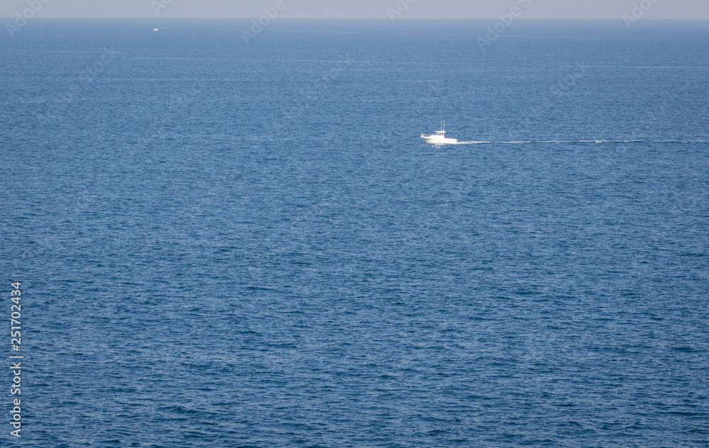 Minimal view of the Cantabrian sea Morning seascape with a lonely boat floating in the middle of the sea