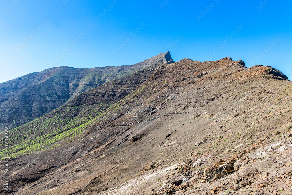 Hiking on Jandia Peninsula, Fuerteventura, Canary Islands, Spain. Mountains in this area (Jandia Massif) divided by deep valleys (barrancos). Fuerteventura is a desert island, the oldest of Canaries