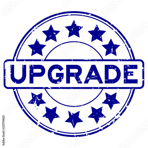 Grunge blue upgrade wording with star icon round rubber seal stamp on white background