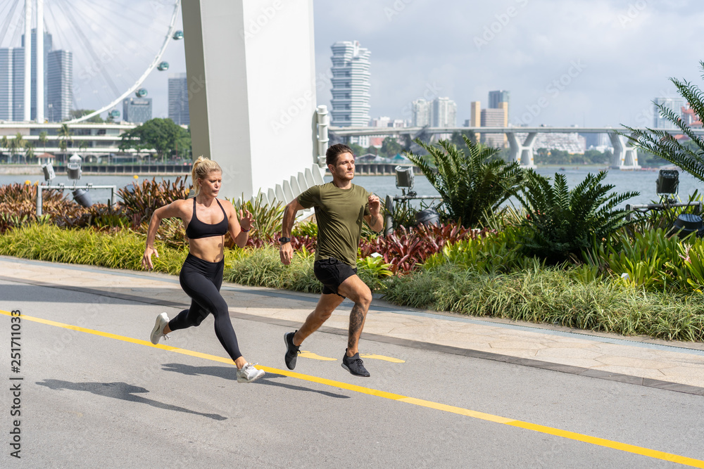 Obraz premium Young fitness couple running in urban area