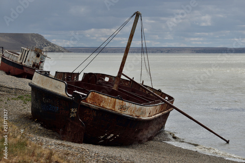 viejos barcos oxidados encallados en la costa durante la marea alta