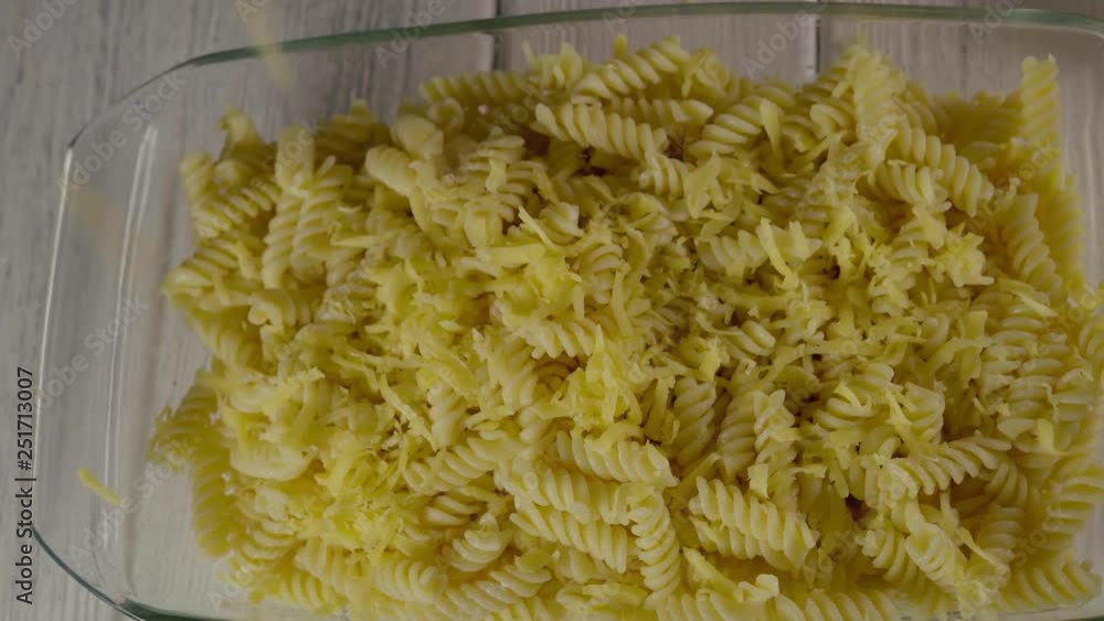 Close-Up, Top View, Grated Cheese Drops on Pasta in Glass Dish Close-Up, Top View, Grated Cheese Drops on Pasta in Glass Dish