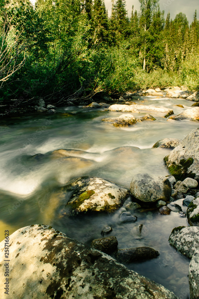 Fast mountain river with stones in stream Fast mountain river with stones in stream