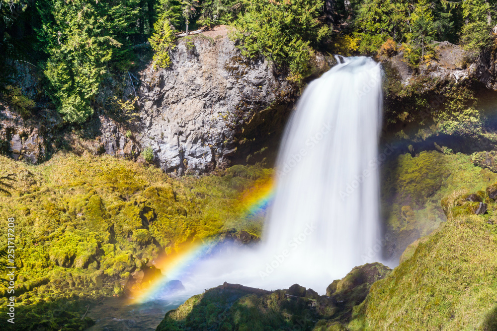 Powerful waterfalls in bright sun with rainbow