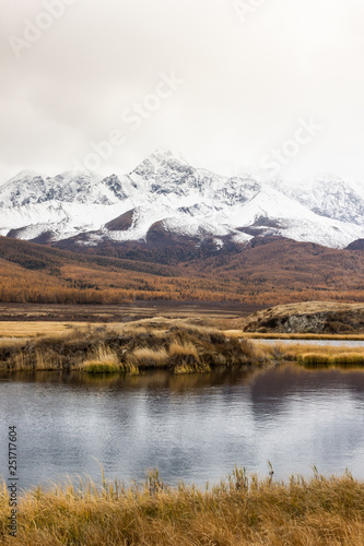 Autumn panorama. View of mountains and lake. Mountain range on horizon. Travel to mountain valley with rivers.