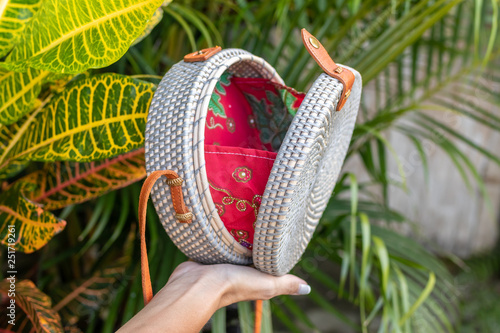 Fashion organic handmade rattan bag on a tropical background. Bali island. photo